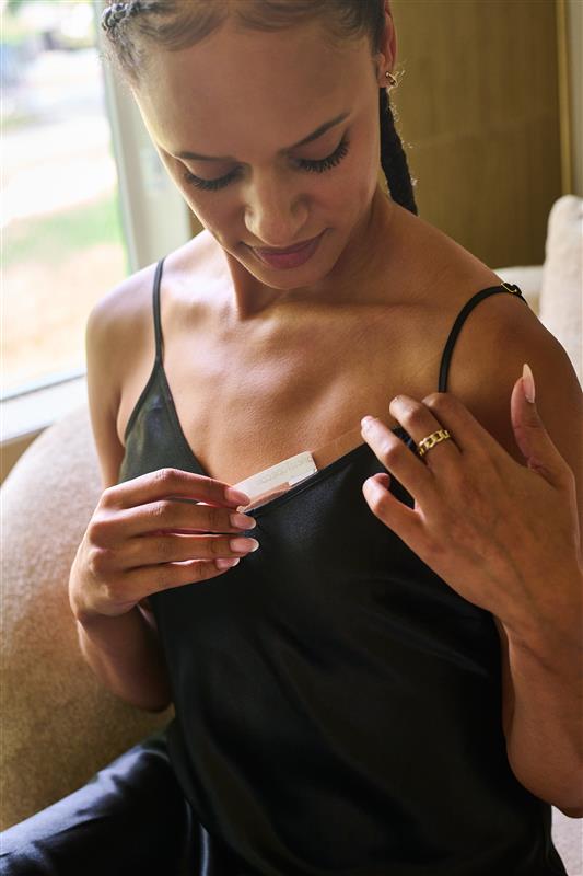 Women applying double sided tape to a delicate dress and sensitive skin